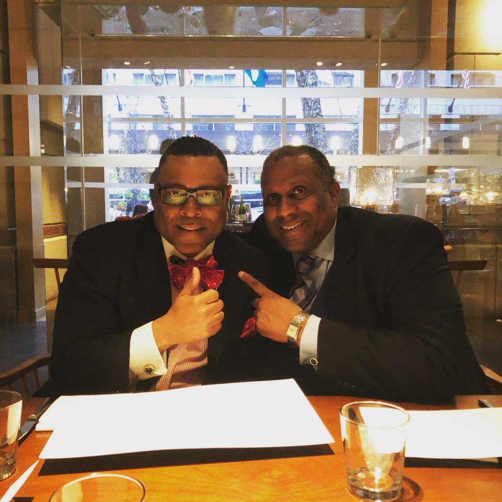 Attorney Arnold Reed posing with a friend in a high-end restaurant