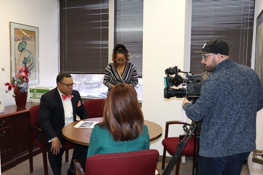 Attorney Arnold Reed sitting at a table with a camera pointed at him whilst interviewing with a news outlet