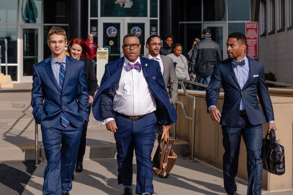 Attorney Arnold Reed, Attorney Arnold Reed II, and a young associate walking away victoriously from the courthouse