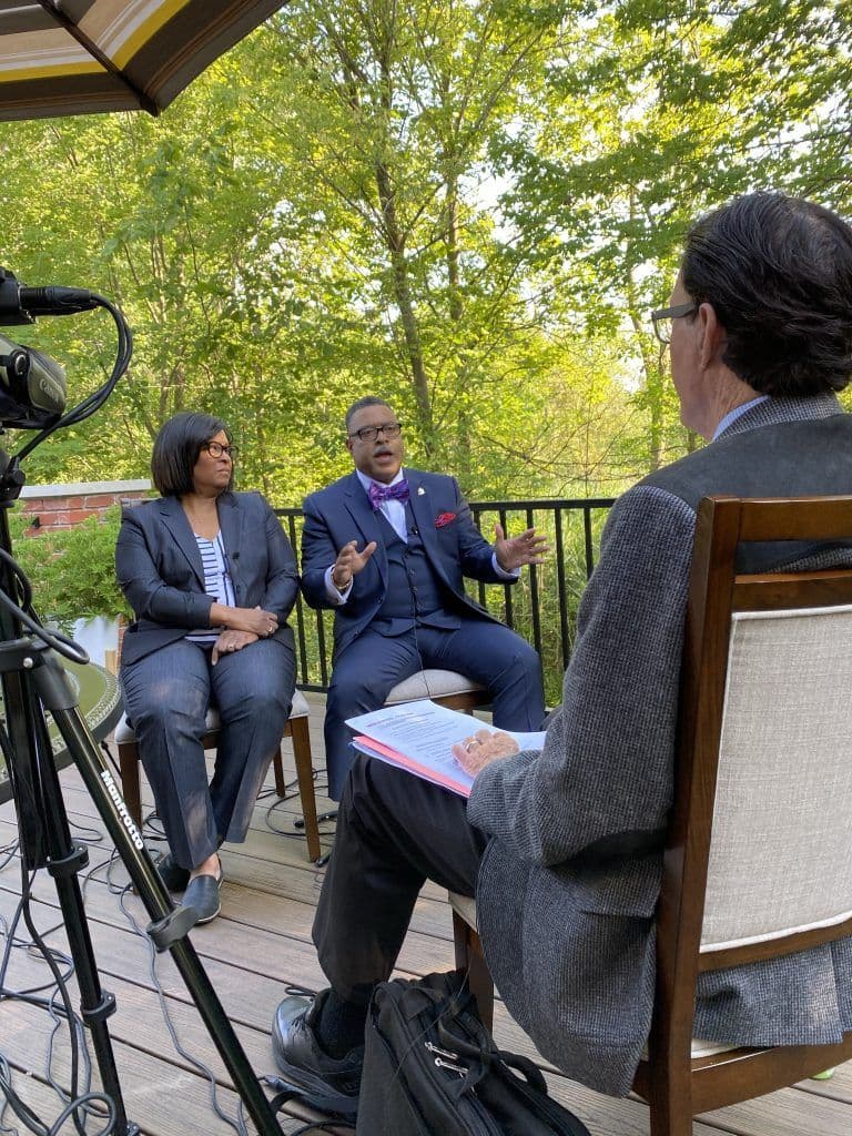 Attorney Arnold Reed and Harolyn D. Beverly taking an interview with a news outlet with the backdrop of a forest